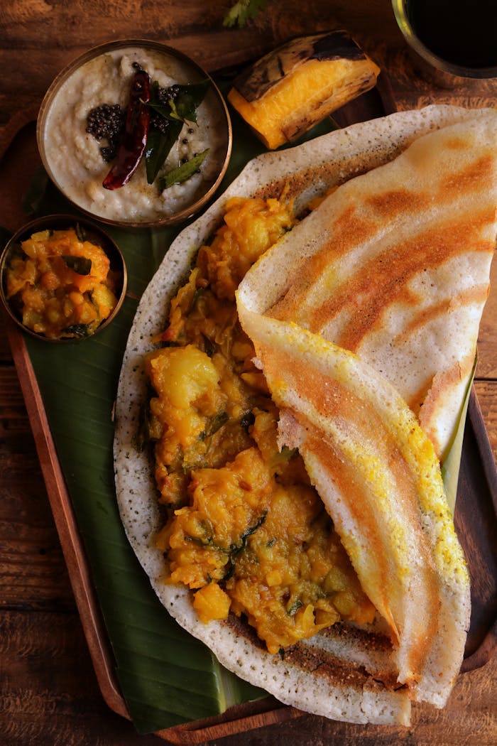 services-04 Close-up of crispy masala dosa served with coconut chutney and sambar.