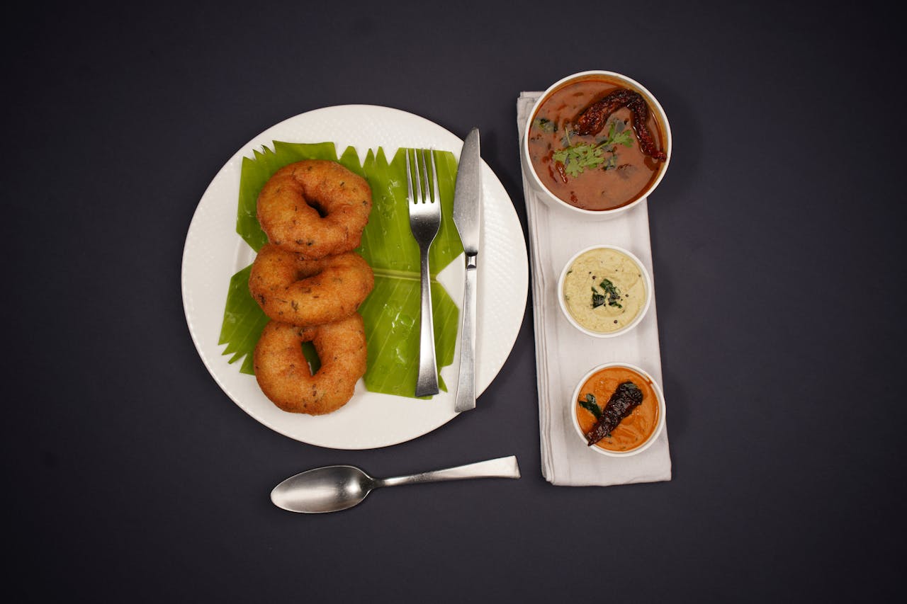 services-01 Delicious South Indian breakfast featuring medu vada and chutneys on a black background.