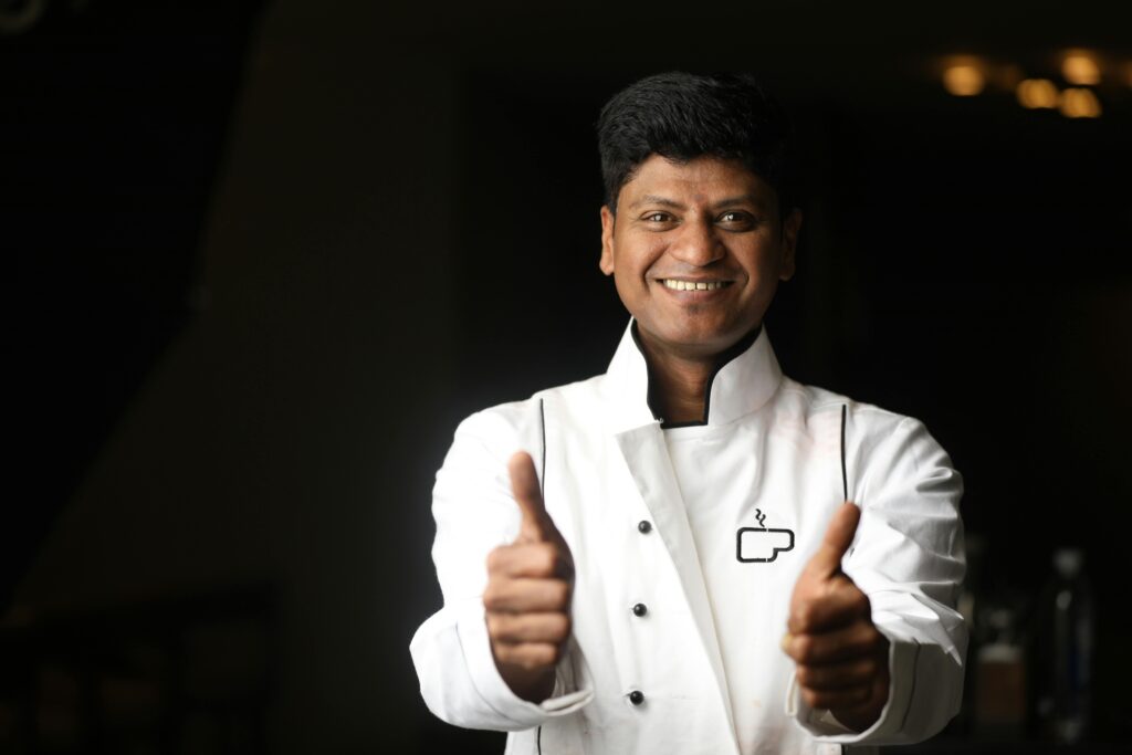 pexels photo 30660319 30660319 A cheerful chef in a white uniform giving a thumbs up, capturing the spirit of hospitality in Bengaluru.
